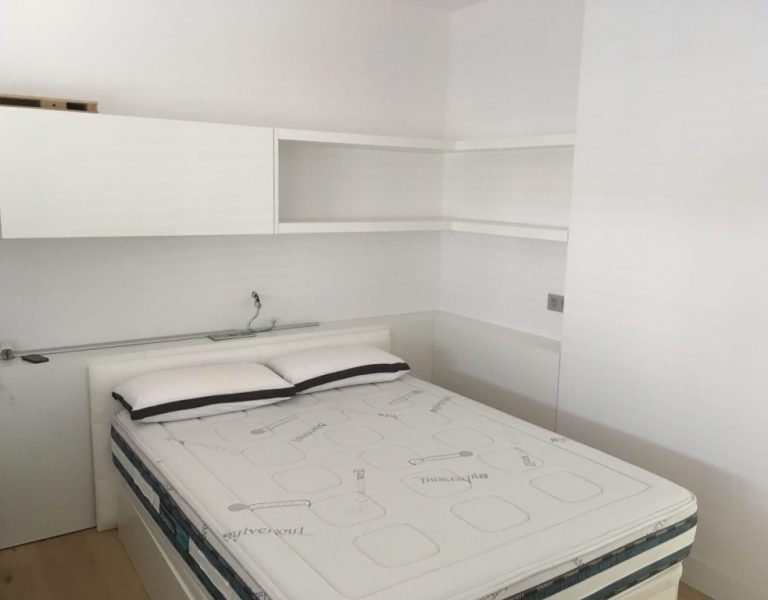Estanteria lacada en blanc fent racó per complimentar l'habitació.